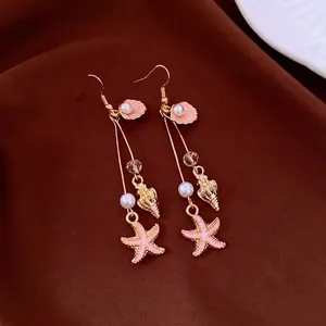 Bohemian ocean-themed earrings featuring pink starfish, conch, and pearl dangles.