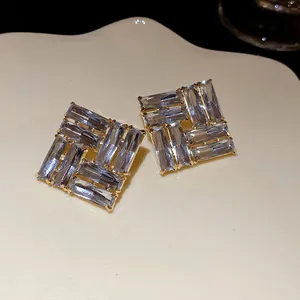 Dettaglio di orecchini quadrati con cristalli blu chiaro e montatura dorata