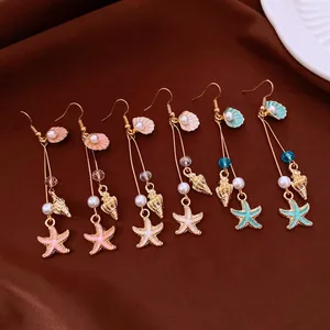 Macro view of Bohemian sea-themed earrings featuring starfish, conch, and pearl charms