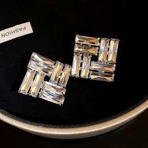 Dettaglio ravvicinato di orecchini a perno quadrati con brillanti cristalli a baguette