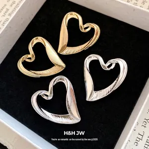 Elegant oversized heart-shaped stud earrings in gold and silver vintage style.
