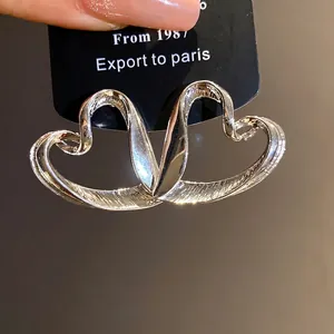 Oversized silver heart earrings with intertwined design and retro textured finish