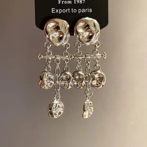 Close-up of vintage silver metal wrinkled long tassel drop earrings on black card