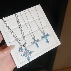 Detailansicht von drei schimmernden blauen Zirkon-Kreuzanhängern in Schmuckschatulle