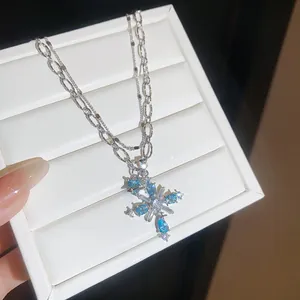 Detailansicht der silbernen Doppelschichtkette mit einem strahlend blauen Zirkon-Kreuzanhänger