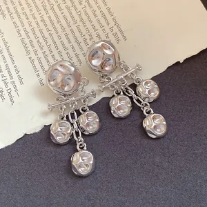 Close-up of vintage silver tassel earrings with a unique crumpled metal texture