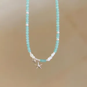 Trendy summer beaded necklace featuring starfish and shell pendants in ocean blue color