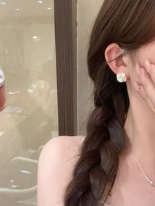 Elegant close-up of white pearl flower stud earrings with zircon worn by an Asian model