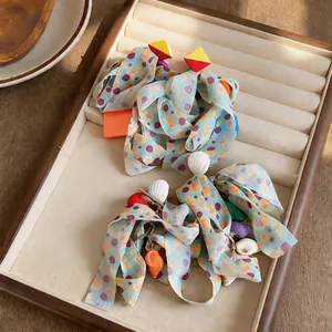 Detail of chiffon bohemian earrings with colorful dots and sea shells on tray