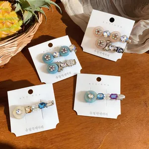 Detailed view of rhinestone bow and resin flower hair clips on display cards