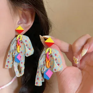 Detailed close-up showing colorful chiffon fabric tassel earrings with geometric rhombus shapes.