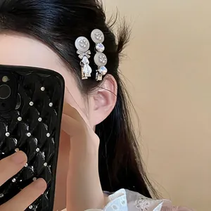 Detail of an Asian model wearing elegant rhinestone flower hair clips in black hair
