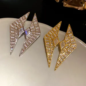 Close-up of geometric diamond-shaped earrings encrusted with sparkling zircons