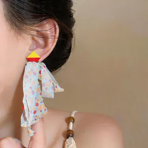 Detail shot of Korean style chiffon ribbon tassel earrings on a model showing flowy texture