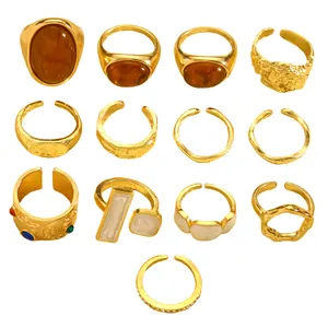 Macro view of vintage gold ring set featuring irregular textures, amber stones and enamel