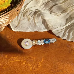 Detailed close-up of a sweet resin hair clip with blue crystal and LUCKY engraving