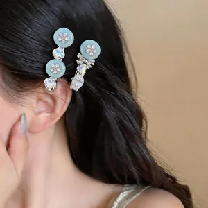 Detail view of elegant blue resin flower and bow hair clips worn on long dark hair