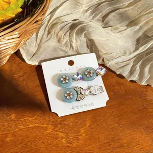 Detailed macro view of elegant resin flower and rhinestone bow hair clips on card.