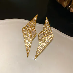 Detail shot of luxury geometric gold earrings encrusted with sparkling cubic zirconia