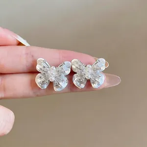 Elegant butterfly stud earrings with shell finish and cubic zirconia accents in silver tone
