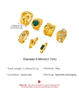 Detailed view of 7pcs vintage gold ring set featuring emerald and crystal accents on white background