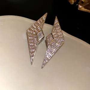 Close-up detail of geometric rhombus zirconia stud earrings with elegant silver finish