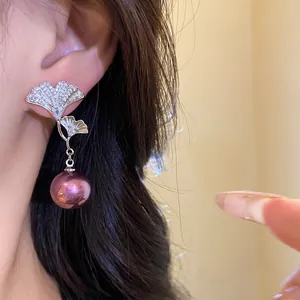 Elegant ginkgo leaf earrings with shimmering zircons and a deep purple pearl pendant.