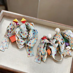 Detail view of Korean chiffon ribbon earrings featuring shells and geometric studs