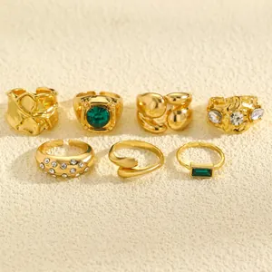 Detailed view of vintage gold ring set featuring irregular textures and emerald stones