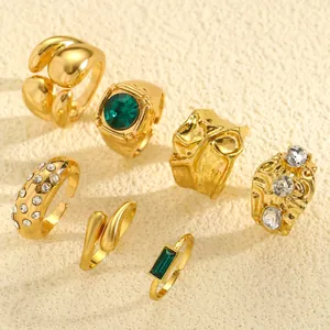 Macro detail view of vintage gold ring set with irregular textures and green stones