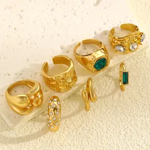 Detailed view of vintage gold ring set featuring irregular textures and green gemstones.