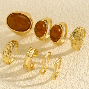 Close-up detail of vintage gold ring set with amber stones and irregular hammered textures.