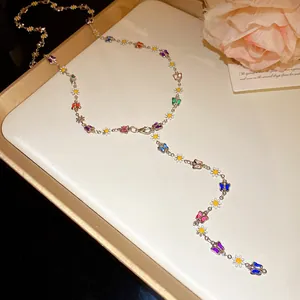 Close-up of elegant Y-shaped necklace featuring colorful enamel butterfly and daisy charms