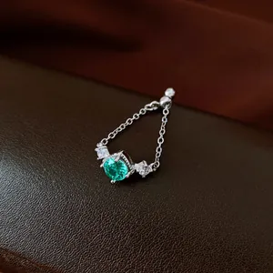 Macro view of vintage chain ring with a green zircon gemstone and delicate silver chain