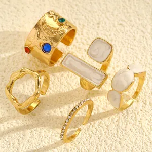 Close-up of vintage gold rings with irregular textures and white enamel details