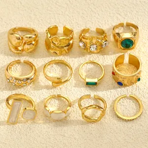 Macro view of a 12-piece vintage gold ring set with irregular textures and colorful gems.