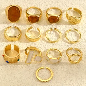 Top view of 13 vintage gold-toned rings with irregular textures and amber resin accents