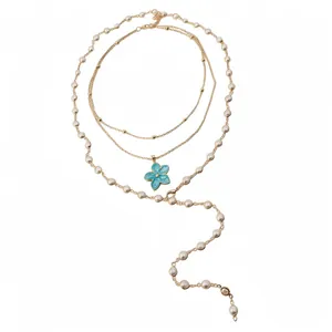 Elegant layered pearl necklace with blue enamel flower pendant in gold tone.