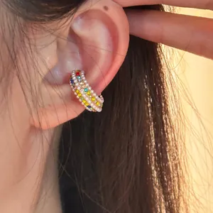 Detailed macro view showing pearls and colorful rhinestones on a C-shaped ear cuff