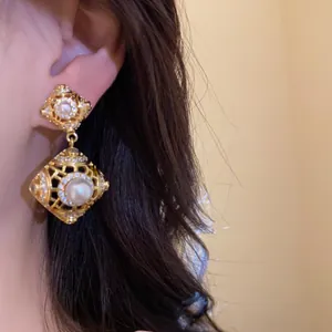 Λεπτομέρεια από vintage χρυσά σκουλαρίκια με πέρλες και λαμπερά κυβικά ζιρκόνια