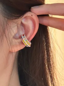 Close-up detail showing a colorful rhinestone and pearl C-shaped ear cuff on an ear