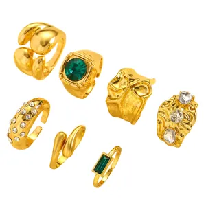 Set of vintage gold-finished irregular rings featuring green emerald stones and textured details