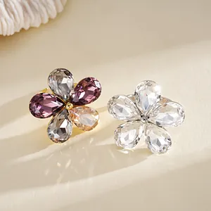 Detailed view of two flower-shaped crystal rings in multi-color and clear styles