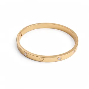 Elegant gold stainless steel bangle bracelet featuring inlaid zircons and heart engraving design