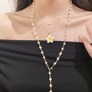 Elegant layered gold necklace set with enamel flower pendant and pearl bead chain details
