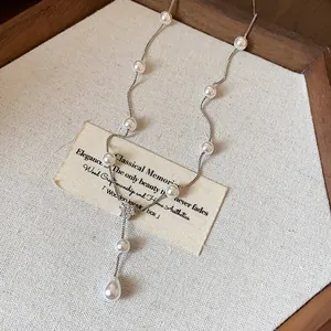 Gros plan d'un collier de perles élégant de style français avec fleur en zircone