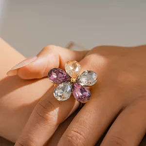 Detail view of a luxury crystal flower open ring worn on a finger with faceted petals.