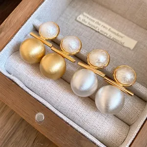 Elegant 18k gold plated brushed metal and pearl stud earrings set in a jewelry box