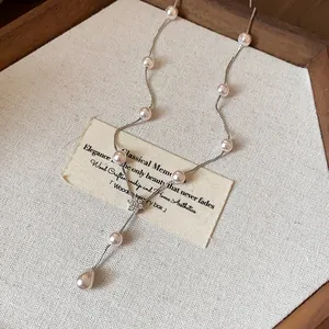 Vue macro d'un élégant collier de perles de style français avec pendentif fleur zircon.