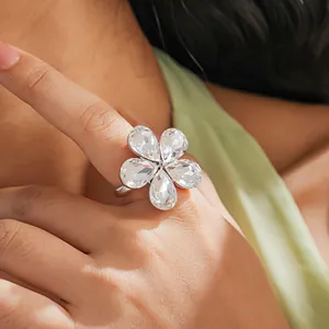 Close-up of an elegant crystal flower open ring with clear teardrop petals on a finger.